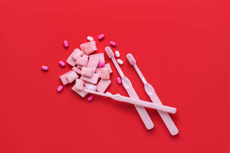 Chewing gums and toothbrushes on color backgroundの写真素材