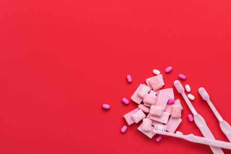 Chewing gums and toothbrushes on color backgroundの写真素材
