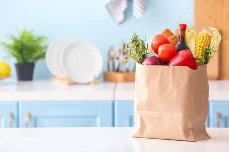 Paper bag with different products on table in kitchenの写真素材