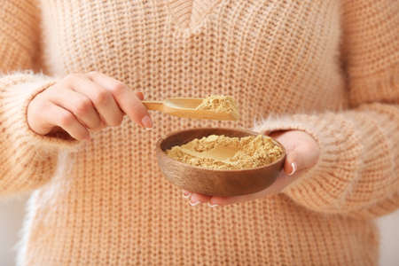Woman with ginger powder in bowl, closeupの写真素材