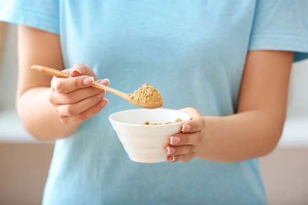 Woman with ginger powder in kitchenの写真素材