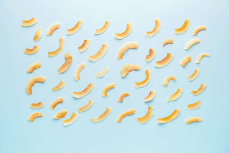 Tasty coconut chips on color backgroundの写真素材
