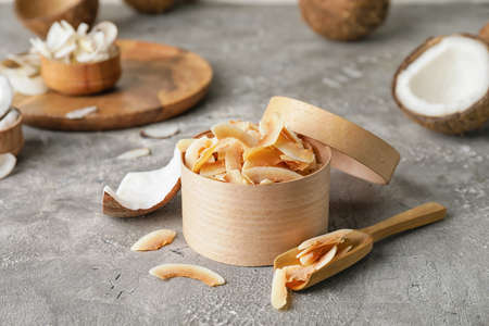 Box with tasty coconut chips on gray backgroundの写真素材