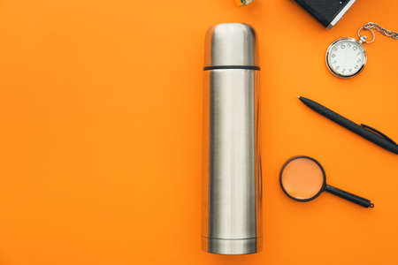 Modern thermos and items for travel on color backgroundの写真素材