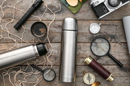 Modern flask and items for travel on wooden background