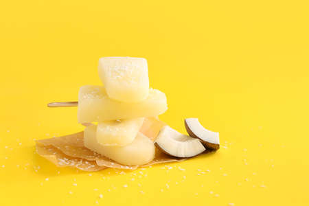 Tasty coconut ice cream on color background