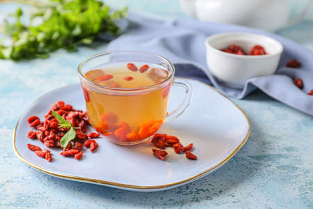 Cup with goji tea on color backgroundの写真素材