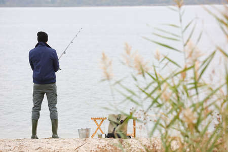 Man fishing on river bankの写真素材