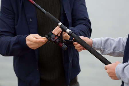 Father and son with fishing rod near river, closeupの写真素材