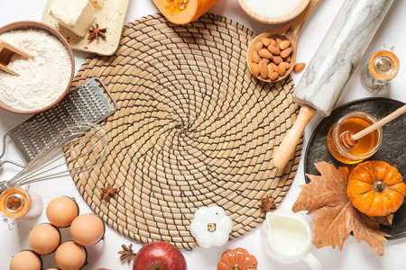 Ingredients for preparing pumpkin pie and mat on white background