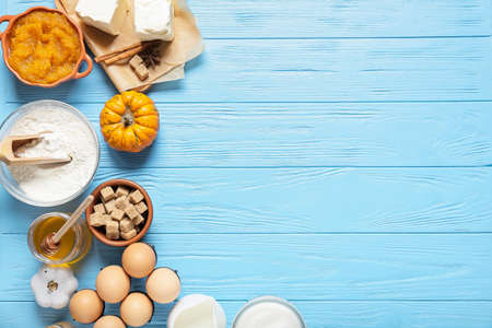 Ingredients for preparing pumpkin pie on color wooden background