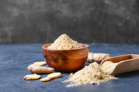 Bowl and scoop with ginger powder on color backgroundの写真素材