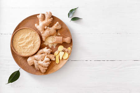 Bowl with ginger powder on light wooden backgroundの写真素材