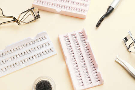 Composition with false eyelashes and tools on color background