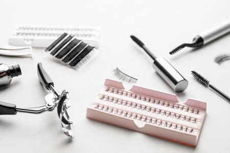 Composition with false eyelashes and tools on light background, closeupの写真素材