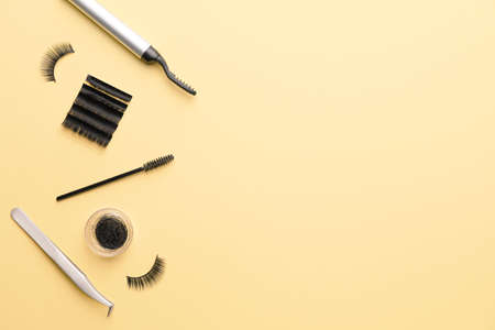 Composition with false eyelashes, black mascara and tools on color backgroundの写真素材