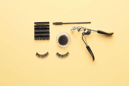 Curler, brush and false eyelashes on color backgroundの写真素材