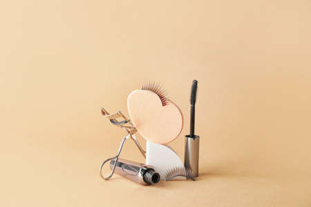 Composition with false eyelashes, black mascara and tools on color backgroundの写真素材