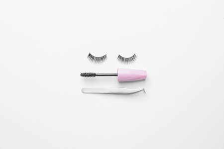 Tweezers, black mascara and false eyelashes on white backgroundの写真素材