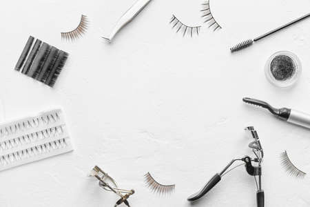 Frame made of false eyelashes and tools on light backgroundの写真素材