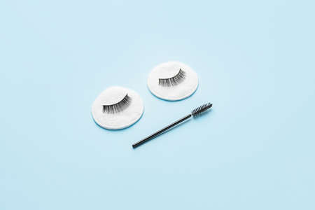 Creative composition with false eyelashes and brush on color backgroundの写真素材