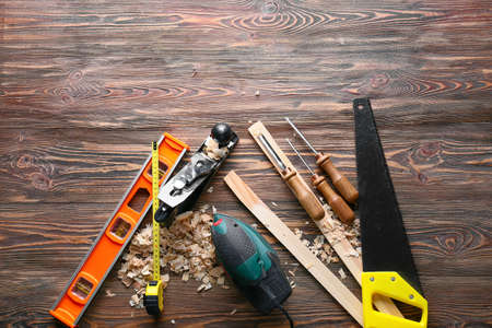 Set of carpenter's tools and saw dust on wooden backgroundの写真素材