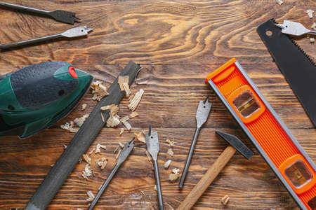 Set of carpenter's tools and saw dust on wooden background