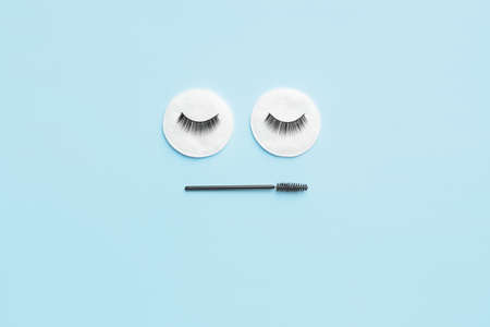 Creative composition with false eyelashes and brush on color backgroundの写真素材