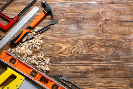 Set of carpenter's tools and saw dust on wooden backgroundの写真素材