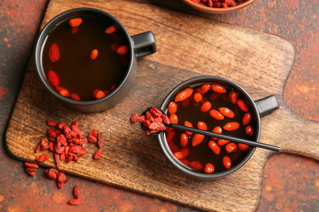 Cups of hot tea with goji berries on grunge backgroundの写真素材