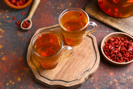 Glass cups of hot tea with goji berries on grunge backgroundの写真素材