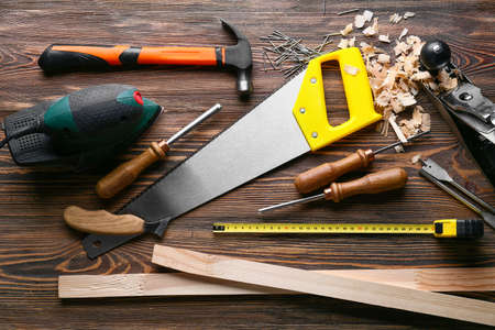 Set of carpenter's tools and saw dust on wooden backgroundの写真素材