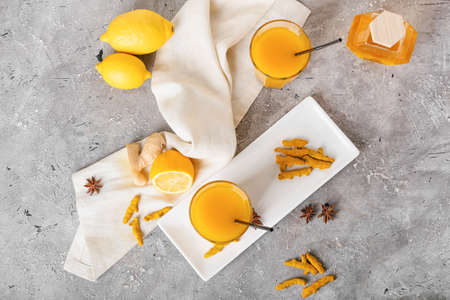 Glasses of healthy turmeric drink on grunge backgroundの写真素材
