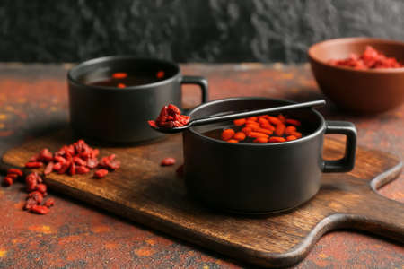 Cups of hot tea with goji berries on grunge backgroundの写真素材