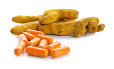 Turmeric pills and roots on white backgroundの写真素材
