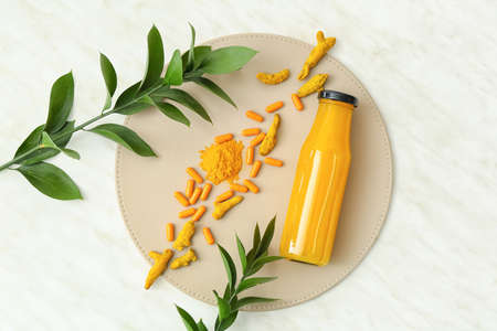 Turmeric pills, powder and bottle with juice on light backgroundの写真素材