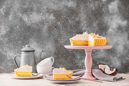 Plates with pieces of tasty coconut pie on tableの写真素材