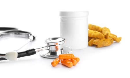 Turmeric pills and stethoscope on white backgroundの写真素材