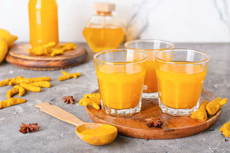 Glasses of healthy turmeric drink on tableの写真素材