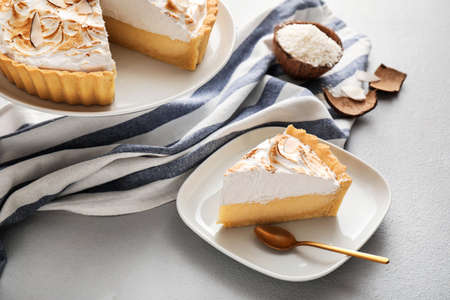 Plate with piece of tasty coconut pie on light backgroundの写真素材