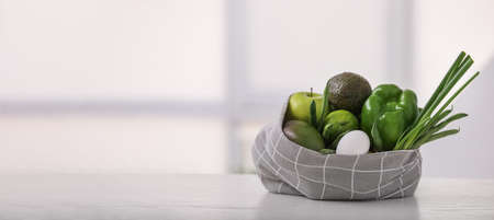 Shopping bag with food on table with space for textの写真素材