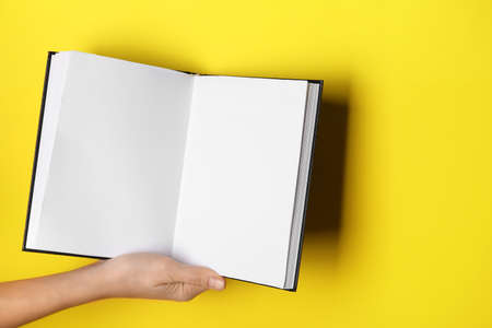 Woman holding open book on color background, closeupの写真素材