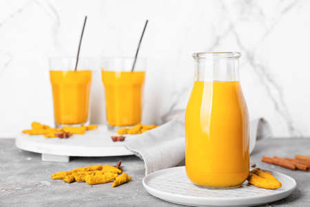 Bottle of healthy turmeric drink on table