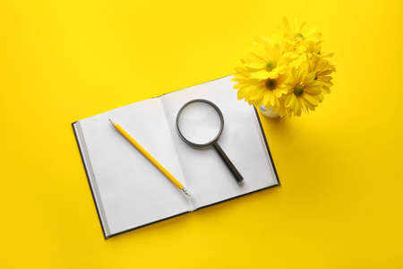 Composition with blank book and flowers on color backgroundの写真素材