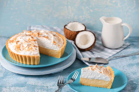 Plates with tasty coconut pie on color backgroundの写真素材