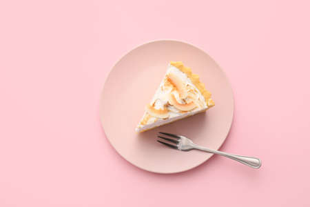 Plate with piece of tasty coconut pie on color backgroundの写真素材