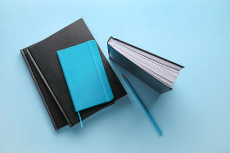 Composition with books, notebook and pencil on color backgroundの写真素材