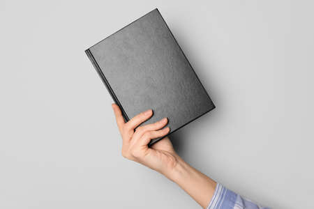Woman holding book on gray backgroundの写真素材