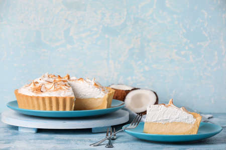 Plates with tasty coconut pie on color backgroundの写真素材