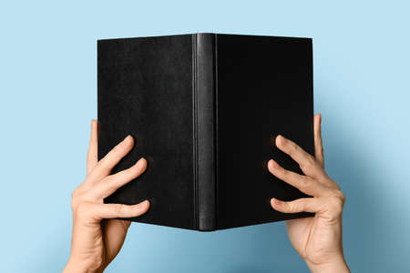 Woman holding open book on color background, closeupの写真素材